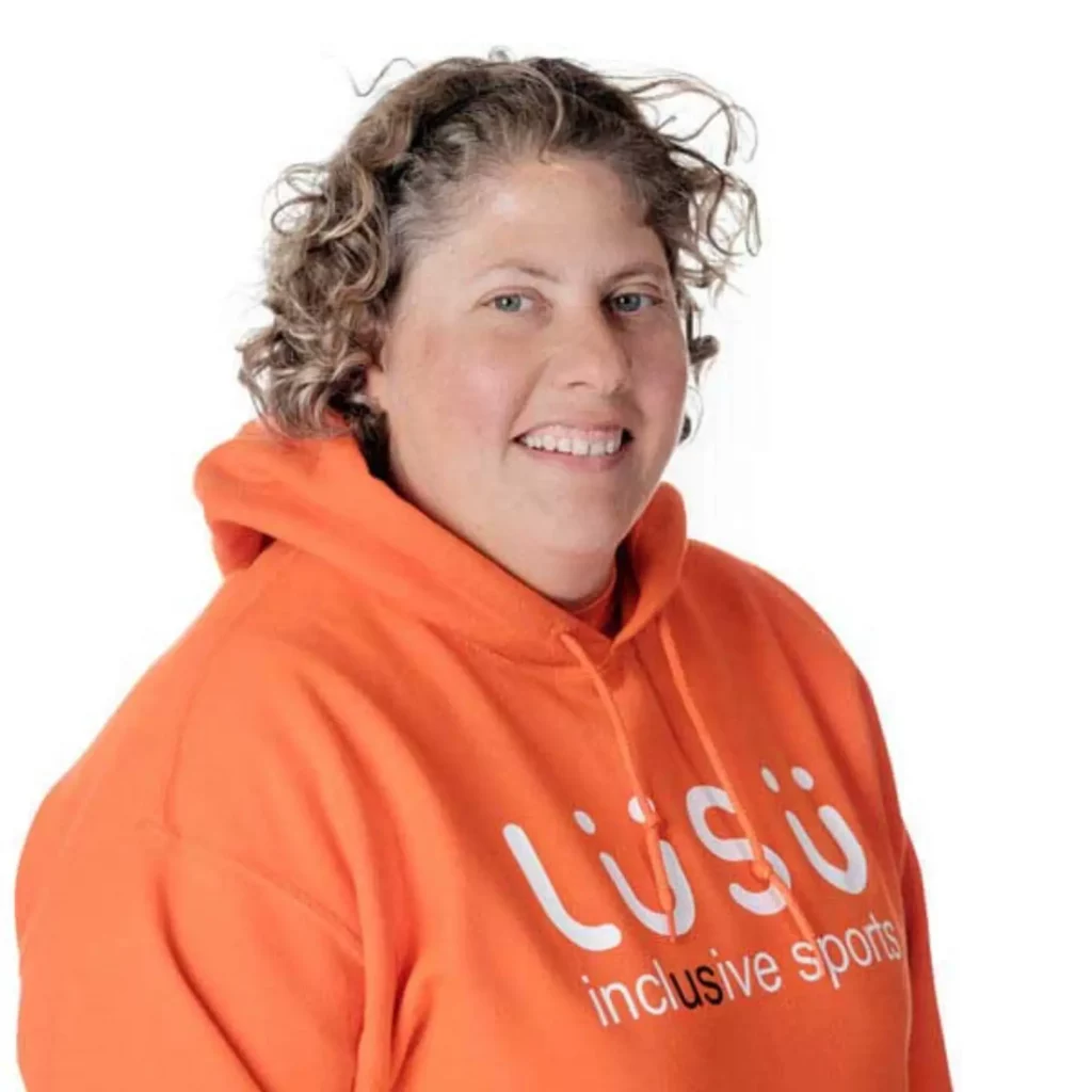 Louise smiling at camera, with bright orange hoody on.