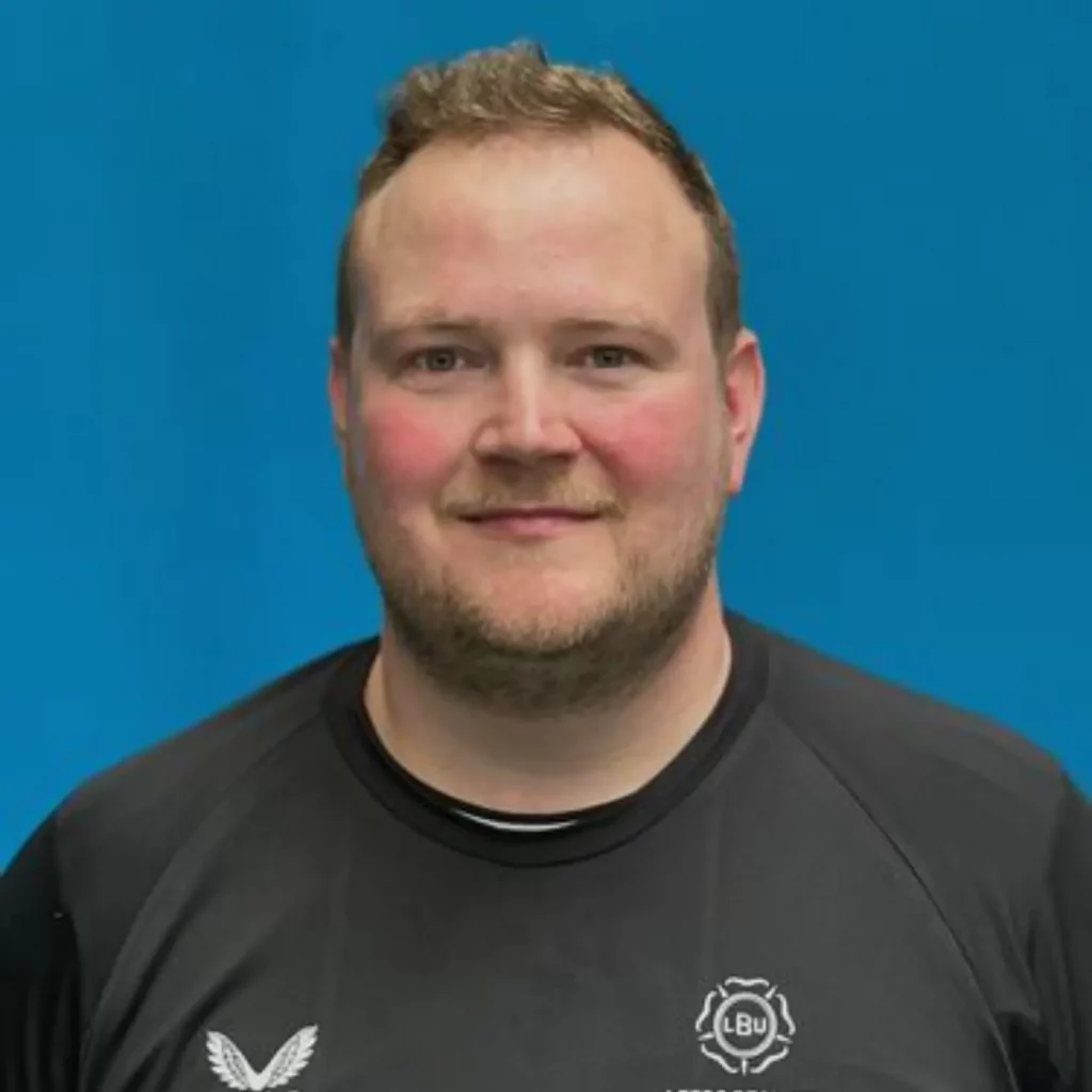 Matt with brown hair, smiling at the camera, with black top on