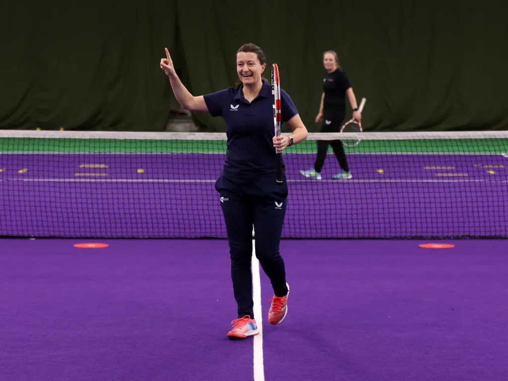 Jo Cunliffe on a tennis court celebrating winning a point